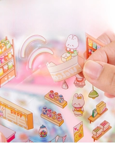 Detail of peeling a 3D transparent PET sticker showing waterproof material and die-cut edge