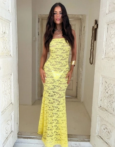 Gros plan détaillé sur la texture de la dentelle jaune d'une robe longue bustier