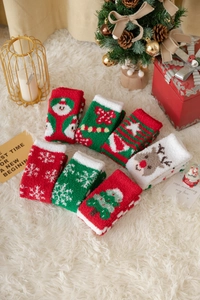 Nahaufnahme von Korallenvlies-Weihnachtssocken mit Weihnachtsmann- und Rentier-Motiven