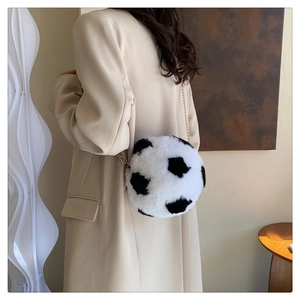 Detail of a soccer-shaped plush crossbody bag with black and white faux fur and gold chain