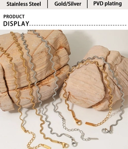 Detailed shot of gold and silver twisted stainless steel necklaces on stone