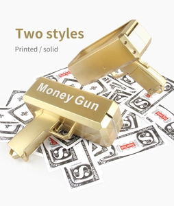 Close-up of golden money gun toy in printed and solid styles on prop banknotes