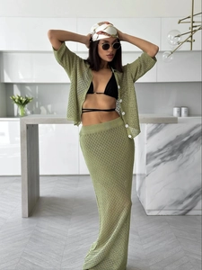 Detail of green crochet knit texture on button-up shirt and high-waist maxi skirt
