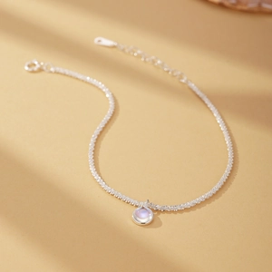 Macro detail of S925 silver bracelet featuring a shimmering moonstone round pendant