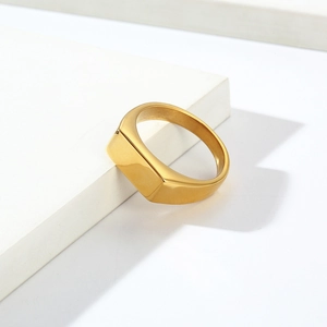 Macro shot of gold signet ring on white geometric stand with professional lighting