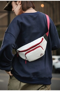Weiße Brusttasche aus Nylon mit rotem Reißverschluss, getragen am Rücken des Models
