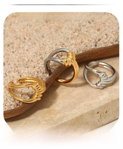 Detail of twisted knot rings in gold and silver finish with high-polished surface