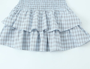 Detailed view of light blue plaid tiered ruffles and fine fabric texture on short dress