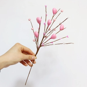 Gros plan de baies roses en forme de cœur et de bourgeons sur une branche flexible