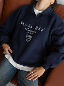 Detail of Prestige Club logo print on vintage half-zip sweatshirt with navy cotton texture