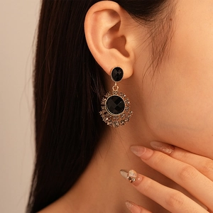 Close-up of vintage sunflower drop earrings with black stones and radiant crystals