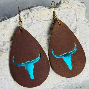Western teardrop leather earrings with turquoise foil bull skull print on stone background