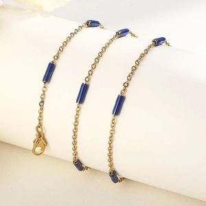 Détail de la chaîne dorée en titane 1,5 mm avec perles émaillées bleu foncé et fermoir