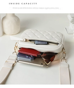 Detail view of the quilted white bag interior capacity with wide fabric strap and gold hardware
