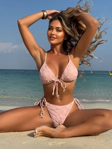 Close-up of pink bikini fabric with floral jacquard texture and snowflake charm details
