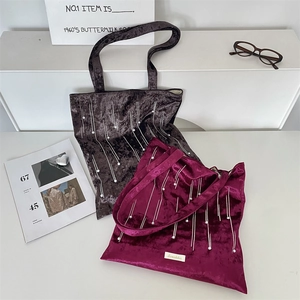 Detail of vintage velvet tote bags with delicate white bead tassel fringe and brand logo