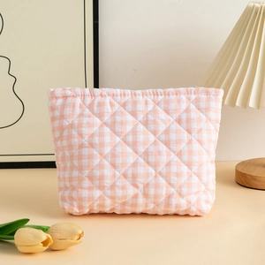 Close-up of pink and white checkered quilted makeup bag with soft fabric texture