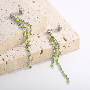 Minimalist titanium steel tassel earrings with neon resin beads on beige travertine base