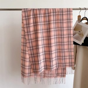 Écharpe à carreaux rose et blanc avec franges suspendue sur un cintre style d'hiver