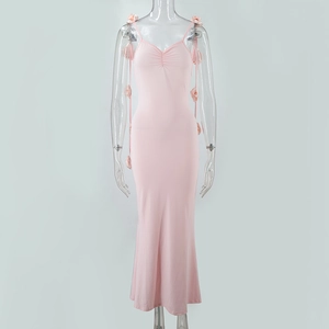 Détail de robe de soirée rose longue avec décorations florales 3D sur les bretelles