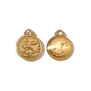 Detail of matte gold Scorpio coin pendants with zodiac reliefs and celestial patterns