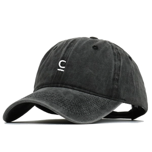 Détail de la lettre C blanche brodée sur la casquette en toile de coton noir délavé