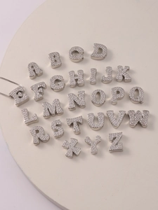 Macro shot of silver A-Z alphabet charms with zircon inlay for jewelry making