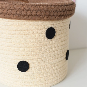 Close-up of cotton rope storage basket featuring black polka dots and brown trim details