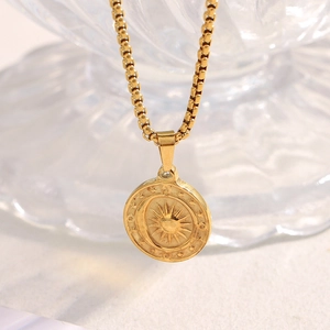 Close-up of 18K gold-plated sun and moon embossed circular pendant on a box chain