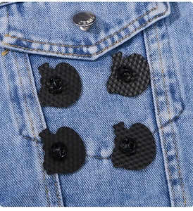 Detail of four black enamel pins with sloths attached to blue denim jacket pocket