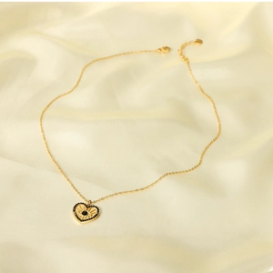 Detail of 18K gold stainless steel heart necklace with evil eye pattern on silk