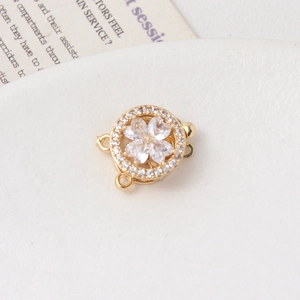 Macro shot of gold clover jewelry clasp with white zircon stones and sparkling crystals