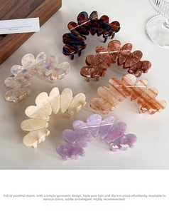 Close-up of wavy acetate hair claws in six marble colors like amber and pearl