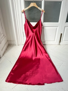 Detail of red silk satin nightgown showing thin straps and draped neckline texture