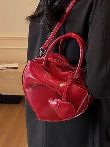 Sac à bandoulière en cuir verni rouge en forme de cœur avec nœud et pendentifs