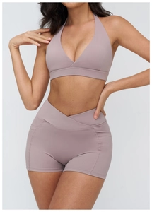 Dettaglio dei pantaloncini yoga a vita alta con design a vita incrociata e tasca laterale