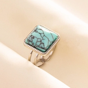 Detail of square turquoise stone ring with black veins on minimalist silver band