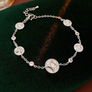 Detail of silver chain bracelet with starburst engraved discs on green velvet