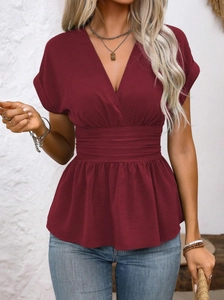 Close-up of V-neckline and pleated waist detail on wine red peplum top for women