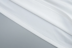 Detailed macro view of white fabric texture with double-needle hem stitching
