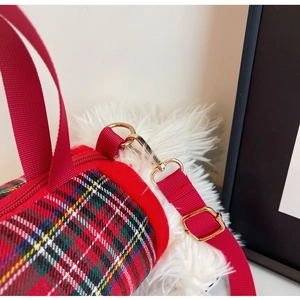 Close-up of red tartan pattern fabric on crossbody bag with golden metal hardware detail