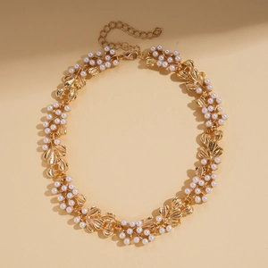 Detailed view of vintage gold leaf necklace with elegant white faux pearls and lobster clasp