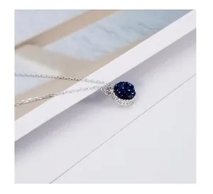 Macro detail of a round blue sandstone pendant on a minimalist 925 sterling silver chain