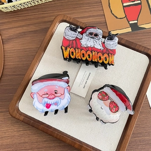 Three festive Santa Claus cartoon hair claw clips set in a wooden tray display