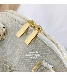 Détails de la fermeture éclair dorée et texture peau de serpent blanche sur le sac