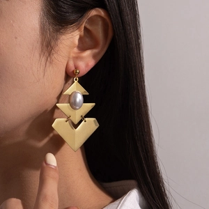 Vintage gold layered geometric triangle earrings with white pearls on a model
