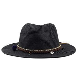 Détail du chapeau de paille noir orné de perles coquillages et glands colorés