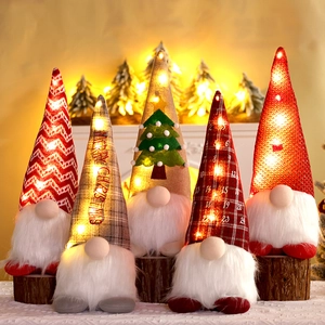Close-up of five light-up Christmas gnomes with LED hats and knitted festive patterns