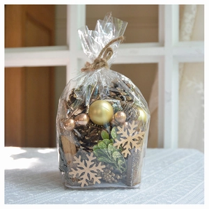 DIY Christmas set with gold pinecones, wooden snowflakes, and ornaments in a clear bag