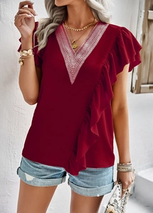 Detail of red short sleeve shirt featuring white V-neck lace and ruffled decorative trim